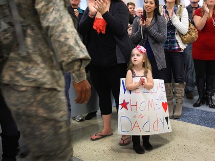 IRVING, TX - DECEMBER 24: Family members and volunteers applaud U.S. troops arriving at the Dallas/Fort Worth International Airport on December 24, 2011 in Irving, Texas. Hundreds of family members and volunteers gathered to meet more than 350 troops who arrived on Christmas Eve for their two-week leave from deployments …