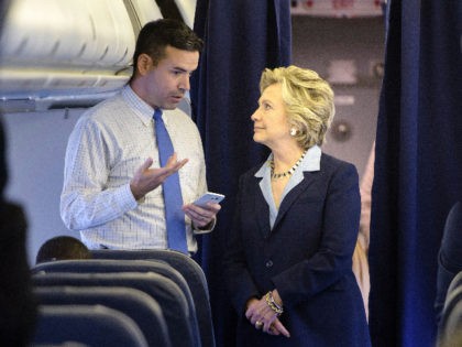 Democratic presidential nominee Hillary Clinton looks at a smart phone with national press secretary Brian Fallon on her plane at Westchester County Airport October 3, 2016 in White Plains, New York. / AFP / Brendan Smialowski (Photo credit should read BRENDAN SMIALOWSKI/AFP via Getty Images)