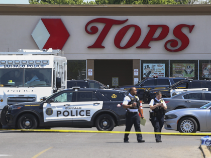 Police walk outside the Tops grocery store on Sunday, May 15, 2022, in Buffalo, N.Y. A white 18-year-old wearing military gear and livestreaming with a helmet camera opened fire with a rifle at the supermarket, killing and wounding people in what authorities described as “racially motivated violent extremism.” (AP Photo/Joshua …