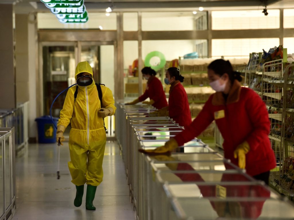 TOPSHOT - Employees spray disinfectant and wipe surfaces as part of preventative measures against the Covid-19 coronavirus at the Pyongyang Children's Department Store in Pyongyang on March 18, 2022. (Photo by KIM Won Jin / AFP) (Photo by KIM WON JIN/AFP via Getty Images)