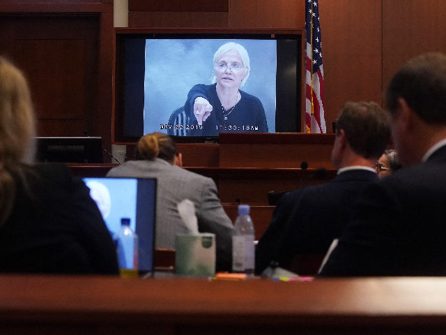 US actor Ellen Barkin appears on a monitor as a recorded testimony from 2019 is played dur