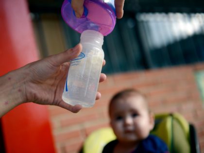 A woman prepares a milk bottle to feed her baby in Caracas on June 18, 2013. The congress would debate about the use of feeding bottle trying to encourage breastfeeding as a way to look after children healt. AFP PHOTO/LEO RAMIREZ (Photo credit should read LEO RAMIREZ/AFP via Getty Images)