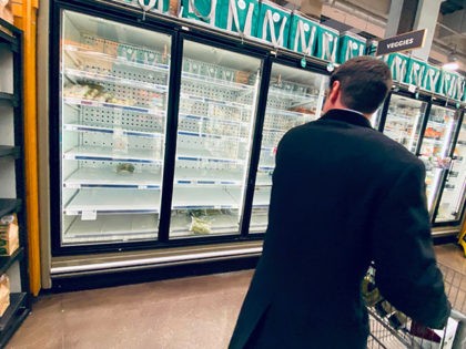 A shopper looks at empty shelves of frozen food in a downtown supermarket on March 11, 2020 in Washington, DC. - People start stocking on non perishable food as the fear of the the novel coronavirus, COVID-19, contagion is rising in the US Capital. (Photo by Eric BARADAT / AFP) …