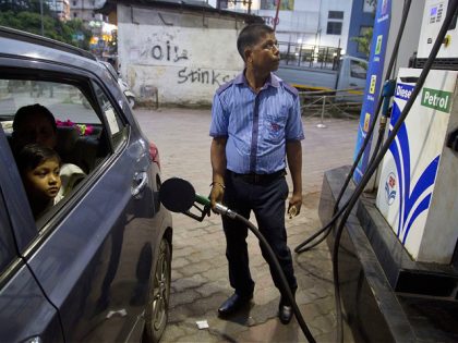 FILE - A man fills his car at a gasoline station in Gauhati, India, Sunday, Sept. 22, 2019