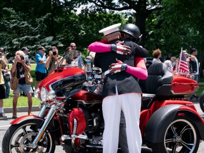 US Marine Corps Staff Sergeant Tim Chambers (Ret.) embraces a participant in the Rolling t