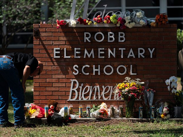A law enforcement personnel lights a candle outside Robb Elementary School in Uvalde, Texas, Wednesday, May 25, 2022. Desperation turned to heart-wrenching sorrow for families of grade schoolers killed after an 18-year-old gunman barricaded himself in their Texas classroom and began shooting, killing several fourth-graders and their teachers. (AP Photo/Jae …