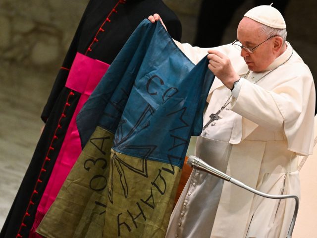 Pope Francis holds a flag of Ukraine that comes from the city of Bucha, one of the areas around Ukraine's capital from which Russian troops have withdrawn and where dozens of bodies in civilian clothing have been found, during the weekly general audience on April 6, 2022 at Paul-VI hall …