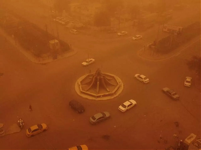 TOPSHOT - An aerial picture shows a view of Iraq's southern city of Nasiriyah during a heavy sandstorm on May 5, 2022. - Iraq is yet again covered in a thick sheet of orange as it suffers the latest in a series of dust storms that have become increasingly common. …