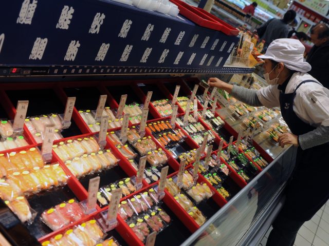 A supermarket worker places sushi in a shop in Hsintien, New Taipei City, on March 16, 201