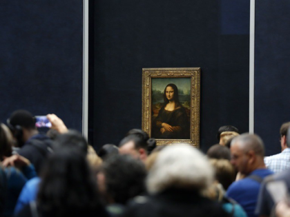 In this Oct.23, 2019 file photo, tourists wait to see Leonardo da Vinci's painting Mona Lisa, at the Louvre museum, in Paris. Iconic sites that are among some of France's biggest tourist draws won't reopen when the country lifts most of its coronavirus restrictions next week. Neither the Louvre Museum, …