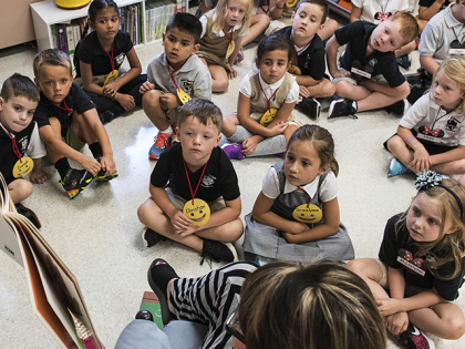 FILE — In this Aug. 22, 2018, file photo, students from two kindergarten classes at the Lewiston elementary campus of Saint Dominic Academy, listen to a teacher read a book, in Lewiston, Maine. School districts across the United States are hiring additional teachers in anticipation of what will be one …