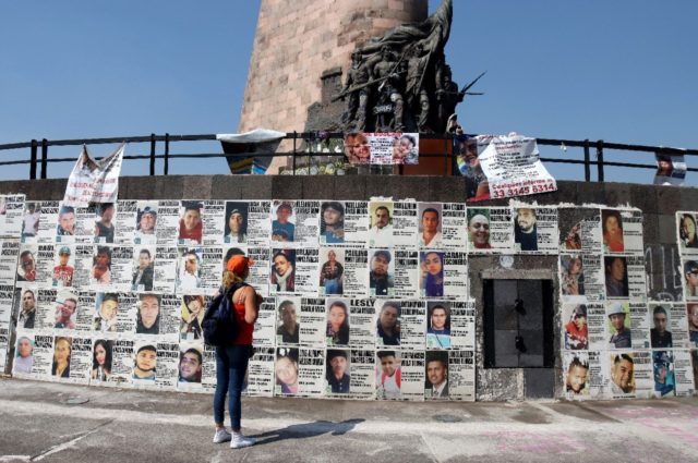A Mexican mother looks at a wall of missing person notices in the western city of Guadalaj