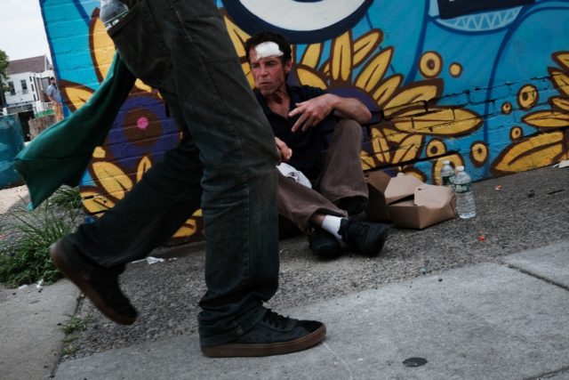 John, who is struggling with a long term addiction to heroin, pauses on a street in Kensin