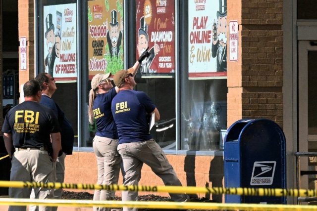 FBI agents look at bullet impacts in the Buffalo, New York grocery store where a gunman li