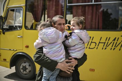 Dmytro Mosur, 32, who lost his wife during shelling in nearby Severodonetsk on May 17, holds his two-year-old twin daughters as they wait to be evacuated from the city of Lysychans’k, eastern Ukraine