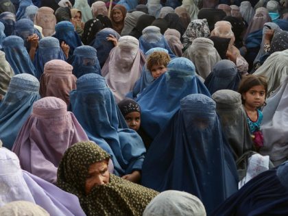 TOPSHOT - Women with their children wait to receive a food donation from the Afterlife fou