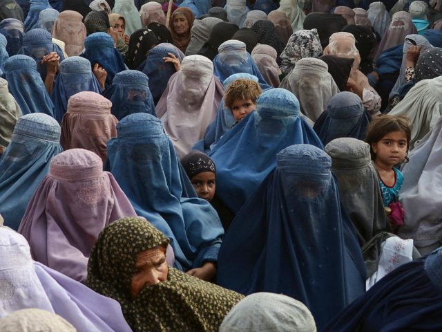 TOPSHOT - Women with their children wait to receive a food donation from the Afterlife foundation during Islam's Holy fasting month of Ramadan in Kandahar on April 27, 2022. (Photo by Javed TANVEER / AFP) (Photo by JAVED TANVEER/AFP via Getty Images)