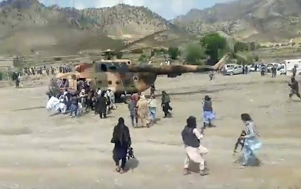 In this image taken from video from Bakhtar State News Agency, Taliban fighters secure a government helicopter to evacuate injured people in Gayan district, Paktika province, Afghanistan, Wednesday, June 22, 2022. An earthquake struck eastern Afghanistan early Wednesday, killing at least 255 people, authorities said. (Bakhtar State News Agency via AP)