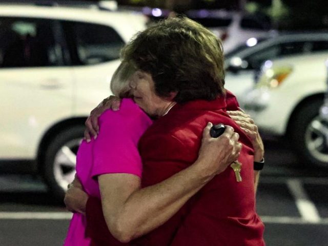 Church members console each other after a shooting at the Saint Stevens Episcopal Church o
