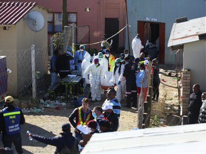 Forensic personel carry a body out of a township pub in South Africa's southern city of East London on June 26, 2022, after 20 teenagers died. - At least 20 teenagers, the youngest aged just 13 years, have died at a township pub in South Africa's southern city of East …