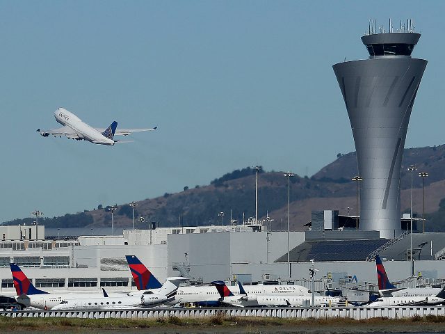 FILE - In this Oct. 24, 2107 file photo, the air traffic control tower is in sight as a pl