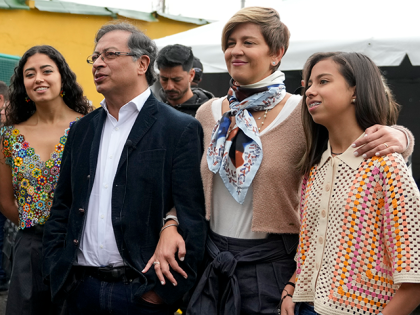 The presidential candidate with the Historical Pact, Gustavo Petro, second from left, talks to journalists upon his arrival to a poling station with his wife Veronica Alcocer, third from left, and their daughters, Antonella, right, and Sofia, left, to vote in presidential elections in Bogota, Colombia, Sunday, May 29, 2022. …