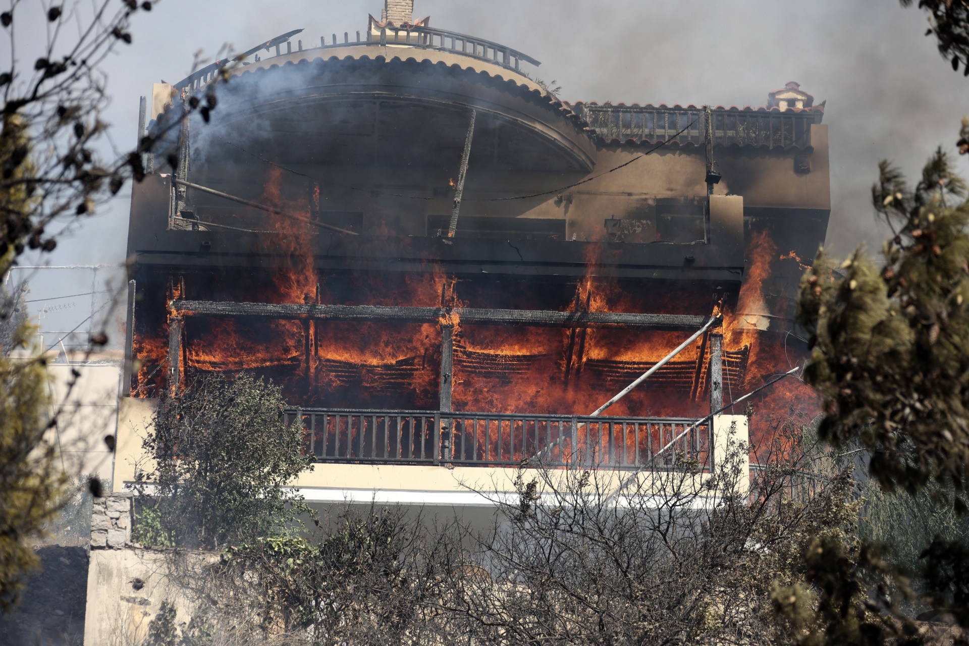Flames burn a house during a wildfire in Voula suburb, in southern Athens, Greece, Saturday, June 4, 2022. (AP Photo/Yorgos Karahalis)