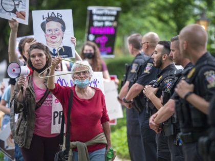 CHEVY CHASE, MD - MAY 18: Police officers look on as abortion advocates hold a demonstration outside the home of U.S. Supreme Court Justice Brett Kavanaugh on May 18, 2022 in Chevy Chase, Maryland. Protests have been organized intermittently outside the homes of justices who signed onto a draft opinion …