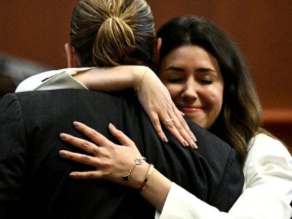Attorney Camille Vasquez embraces US actor Johnny Depp in the courtroom at the Fairfax County Circuit Courthouse in Fairfax, Virginia, on May 17, 2022. - Depp is suing ex-wife Amber Heard for libel after she wrote an op-ed piece in The Washington Post in 2018 referring to herself as a …