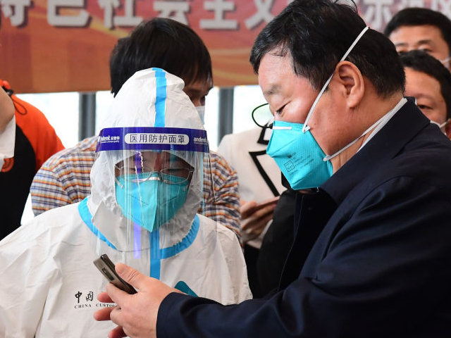 SHENZHEN, CHINA - FEBRUARY 28: A customs officer checks the health QR code of Liang Wannian who leads a team of Chinese mainland medical experts at Shenzhen Bay Port on February 28, 2022 in Shenzhen, Guangdong Province of China. The medical team arrives in Hong Kong on Monday and will work with the Hong Kong Special Administrative Region (HKSAR) government in fighting the latest COVID-19 outbreak. (Photo by Chen Wen/China News Service via Getty Images)