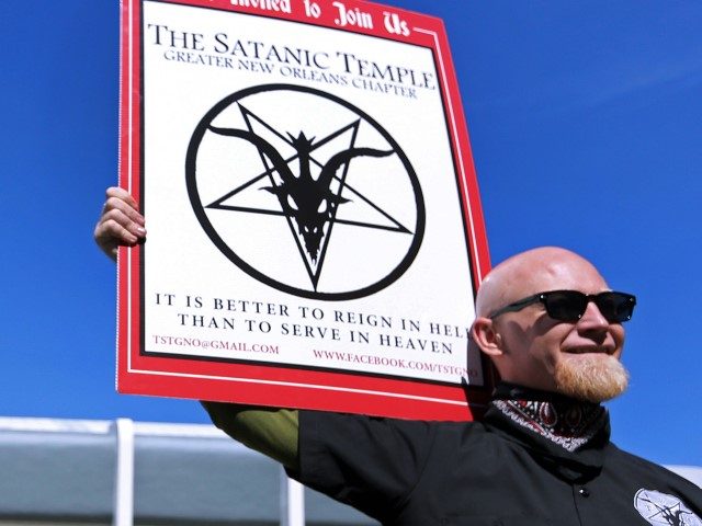 In this Jan. 24, 2015, file photo, Chris Bridges holds a sign for The Satanic Temple during a protest outside of an all-day prayer rally headlined by Louisiana Gov. Bobby Jindal in Baton Rouge. The Phoenix council was poised Wednesday, Feb. 3, 2016, to consider whether a group that uses …