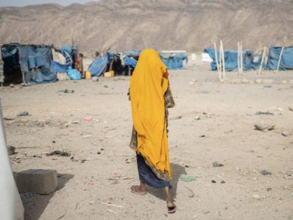 A woman walks past a tent at the internally displaced persons (IDP) camp of Guyah, 100 kms of Semera, Afar region, Ethiopia on May 17, 2022. - Conflict erupted in Ethiopia late 2020 when the government sent troops in to topple Tigray's ruling TPLF party, saying it was in response …