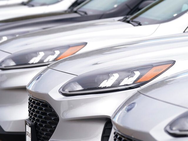 A long row of unsold 2021 Escape models sits at a Ford dealership Sunday, Dec. 20, 2020, in Centennial, Colo. (AP Photo/David Zalubowski)