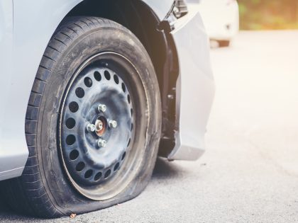 Punctured Car On Road - stock photo