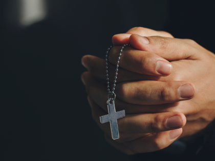 Close up hands holding Cross necklace.Pray for god blessing to wishing have a better life - stock photo