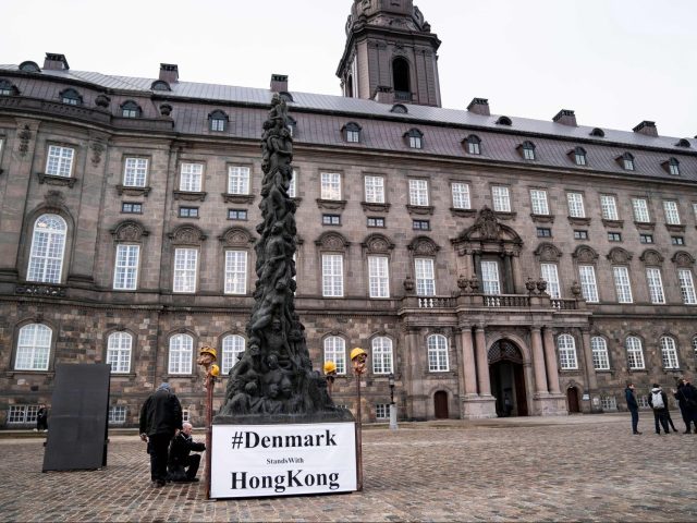 Danish artist Jens Galschiot (L) works in front of the Danish Parliament Folketinget at Christiansborg Palace Square in Copenhagen, where he erected an 8-meter-high Pillar of Shame in solidarity with the protesters in Hong Kong on January 23, 2020. (Photo by Liselotte Sabroe / Ritzau Scanpix / AFP) / Denmark OUT (Photo by LISELOTTE SABROE/Ritzau Scanpix/AFP via Getty Images)