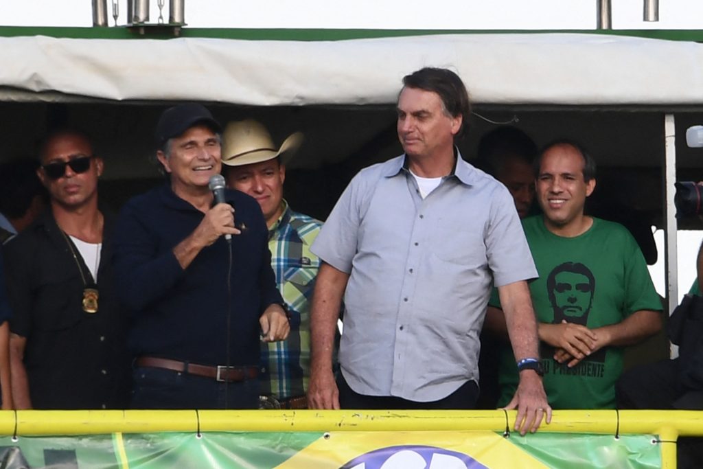Brazilian President Jair Bolsonaro (R) and former F1 champion Nelson Piquet attend a demonstration by farmers against the Supreme Court and calling for the end of COVID-19 restrictions, in Brasilia, on May 15, 2021 - The rally's organizers have called for conservative "soldiers" to protest the "craziness" of pandemic stay-at-home measures and Brazil's Supreme Court, which allowed local authorities to impose such policies over Bolsonaro's objections. (Photo by EVARISTO SA / AFP) (Photo by EVARISTO SA/AFP via Getty Images)