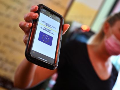 A customer shows her Green Pass on a mobile phone in a central Rome bar on August 6, 2021, as Italy made the Green Pass, which is an extension of the EU's digital Covid certificate, required from today to enter cinemas, museums and indoor sports venues, or eat indoors at …