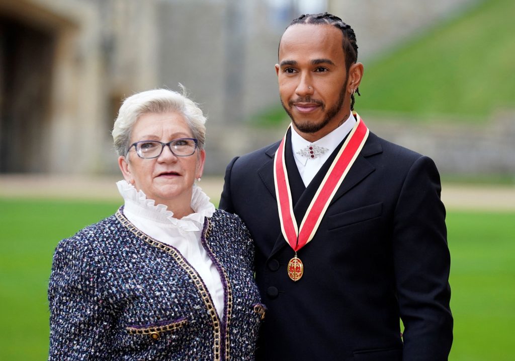 Mercedes' British driver Lewis Hamilton stands with his with his mother Carmen Lockhart, as he poses with his medal after being appointed as a Knight Bachelor (Knighthood) for services to motorsports, by the Britain's Prince Charles, Prince of Wales, during a investiture ceremony at Windsor Castle in Windsor, west of London on December 15, 2021. - Lewis Hamilton received his knighthood on Wednesday as the British driver comes to terms with controversially losing the Formula One world title. (Photo by Andrew Matthews / POOL / AFP) (Photo by ANDREW MATTHEWS/POOL/AFP via Getty Images)
