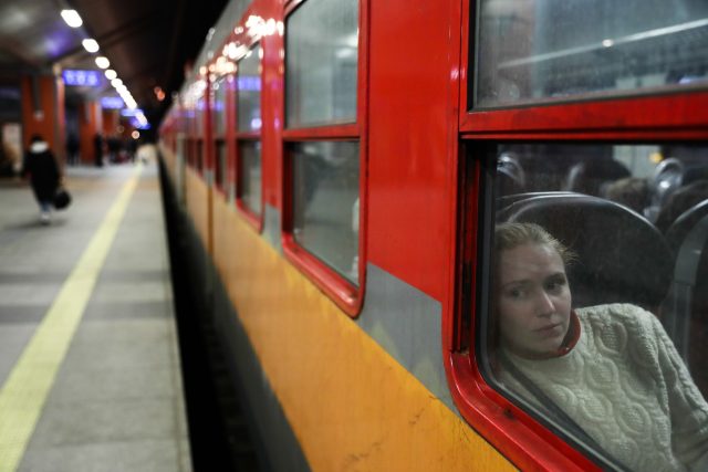 A woman fleeing from Ukraine looks through the train's window at the train station in