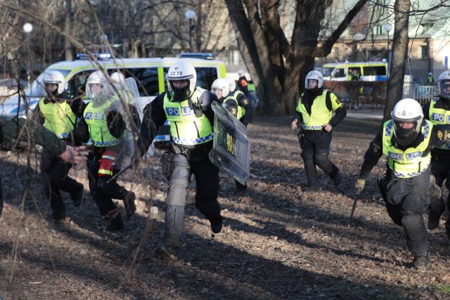 Police officers charge during a counter-protest in the park Sveaparken in Orebro, south-ce
