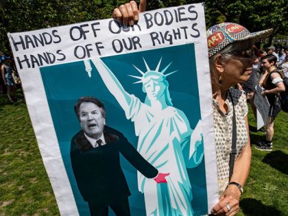 An activist carries a placard with an image of US Supreme Associate Justice Brett Kavanaug