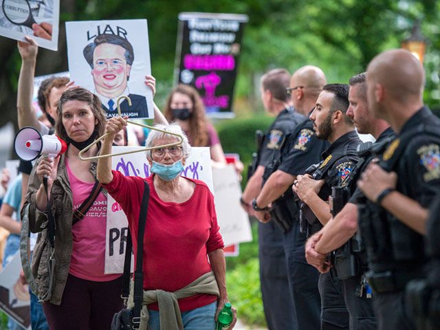 CHEVY CHASE, MD - MAY 18: Police officers look on as abortion-rights advocates hold a demonstration outside the home of U.S. Supreme Court Justice Brett Kavanaugh on May 18, 2022 in Chevy Chase, Maryland. Protests have been organized intermittently outside the homes of justices who signed onto a draft opinion …