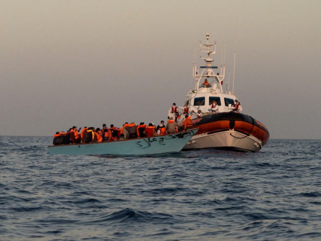 ITALY - 2022/05/18: The migrant's boat seen next to the Italian Coast Guard. The crew