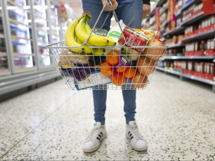 CARDIFF, WALES - MAY 22: A woman holds a shopping basket of groceries on May 22, 2022 in Cardiff, Wales. Last week, the UK Office for National Statistics reported an 6% average increase of food and drink prices year on year, but some staples, such as milk and pasta, had …