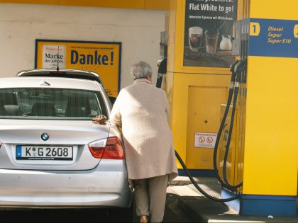 a woman pumps gasoline into his car at an Jet gas station in Cologne, Germany on June 1, 2