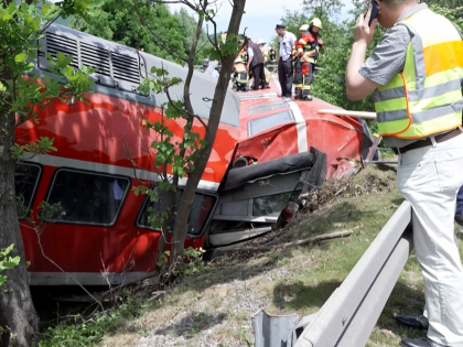 This video grab shows firemen and rescue helpers working around a derailed train on June 3, 2022 in Burgrain near Garmisch-Partenkirchen, southern Germany. - At least three people were killed and several others injured as a train derailed near a Bavarian Alpine resort in southern Germany, police said. (Photo by …