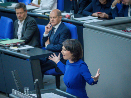03 June 2022, Berlin: Annalena Baerbock (Bündnis90/Die Grünen), Foreign Minister, speaks in the plenary chamber in the Bundestag. In the background, Robert Habeck (Bündnis 90/Die Grünen - l), Federal Minister for Economic Affairs and Climate Protection, and Federal Chancellor Olaf Scholz (SPD) listen to her. An amendment to the Basic …