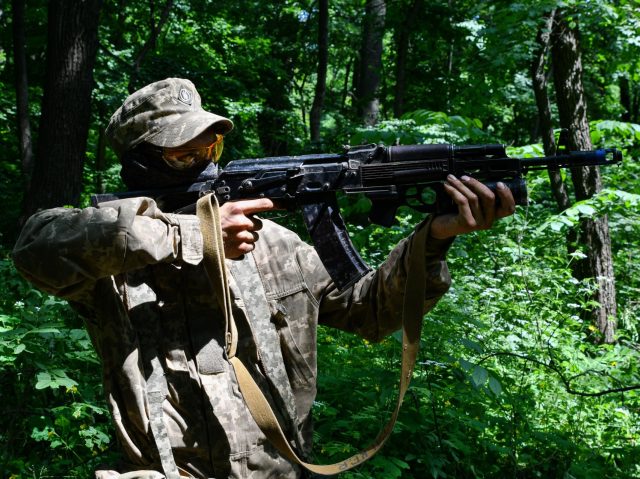 SVIATOHIRSK, UKRAINE - 2022/05/30: A Ukrainian serviceman practicing in the forest before