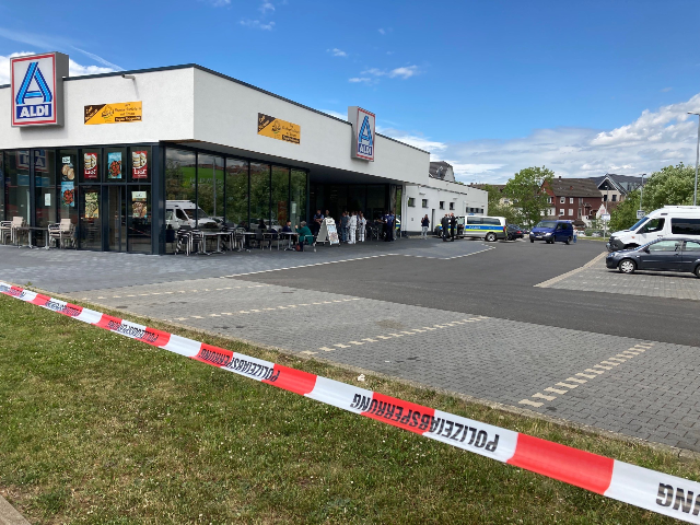 07 June 2022, Hessen, Schwalmstadt: Flutter tape hangs in front of a supermarket. In the c